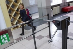 A girl passes through a security turnstile at a school in central Moscow.