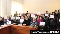 Находящиеся в зале суда сторонники журнала ADAM bol поднимают плакаты в поддержку издания. Алматы, 26 февраля 2015 года.