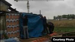 Рабочие и представители городского акимата срывают портреты президента Нурсултана Назарбаева с дачного дома жительницы Астаны Раушан Уябаевой. 13 мая 2017 года. Фото предоставлено Лесбеком Уябаевым.