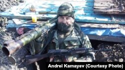 Andrei Kamayev poses with an antitank missile launcher and a Kalashnikov rifle in a trench in eastern Ukraine in January 2015.