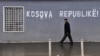 Kosovo -- An ethnic Albanian man walks past a graffiti reading "Kosovo Republic" in the town of Pristina, 24Feb2012