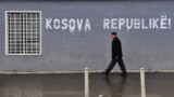 Kosovo -- An ethnic Albanian man walks past a graffiti reading "Kosovo Republic" in the town of Pristina, 24Feb2012