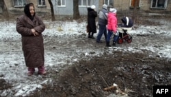 Донецк облысының Макеевка селосының тұрғыны снаряд түсіп, ойылып қалған жерге қарап тұр. Украина, 27 қаңтар 2015 жыл. 