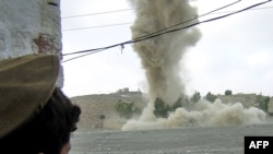 Tribesman watches an alleged Taliban hideout being blown up during a military operation in March