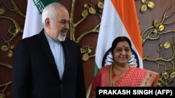 Indian Foreign Minister Sushma Swaraj (right) poses for photos with Iranian Foreign Minister Mohammad Javad Zarif prior to a meeting in New Delhi on May 14. 