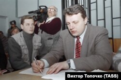 1997 жылы ОРТ телеарнасы көрсеткен сюжеттен кейін Беларусь мемлекеттік шекарасын заңсыз кесіп өтті деген айыппен жауапқа тартылған телеоператор Дмитрий Завадский (сол жақта) мен журналист Павел Шеремет Ошмянск ауданы сотында отыр. 17 желтоқсан 1997 жыл.