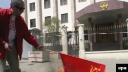 Грузинская сторона сравнивает последние действия России с агрессией Советского Союза. Во время пикета у российского посольства житель Тбилиси поджег советский флаг