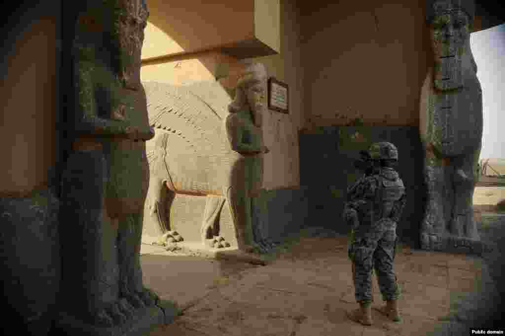 A member of the U.S. Air Force documents sculptures on the entrance to an ancient palace in November 2008.