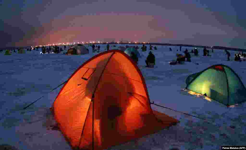 Fishermen gather to catch smelts through the ice on the Kursiai Lagoon near Klaipeda, Lithuania, on January 27.