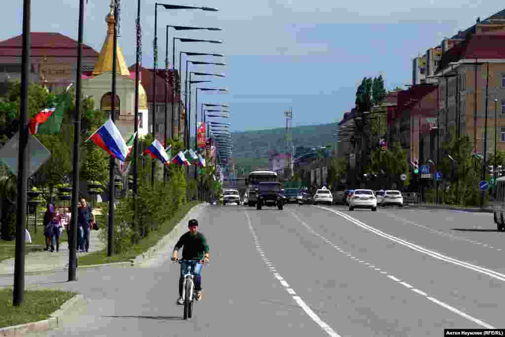 Велосипедист и флаги России на улице в Грозном.