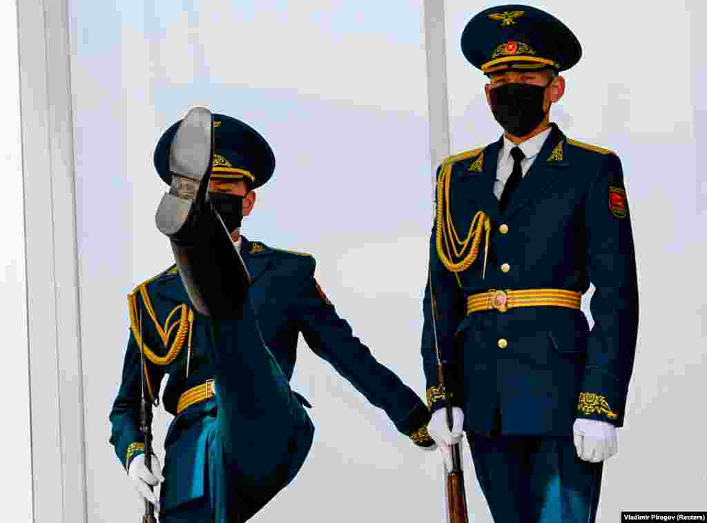 Wearing protective masks, Kyrgyz servicemen take part in a changing-of-the-guards ceremony in Bishkek. (Reuters/Vladimir Pirogov) &nbsp;