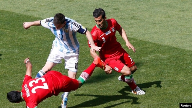 Argentina's Lionel Messi fights for the ball against Iran's Mehrdad Pouladi (L) and Ehsan Hajsafi (R) during their 2014 World Cup Group F soccer match. June 21, 2014