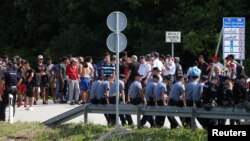 Migranti i pripadnici policije BiH kod granice sa Hrvatskom, lipanj 2018.