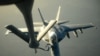 Un avion de tip F-18E Super Hornet al marinei militare americane alimentat cu carburant de un aparat KC-135 Stratotanker deasupra nordului Irakului după ce a efectuat un atac în Siria northern Iraq after conducting air strikes in Syria, 23 September 2014