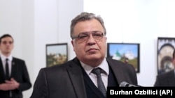 Andrei Karlov, the late Russian Ambassador to Turkey, at an exhibition in Ankara moments before he was shot dead by Mevlut Mert Altintas, who is visible in the background on the left. (file photo)