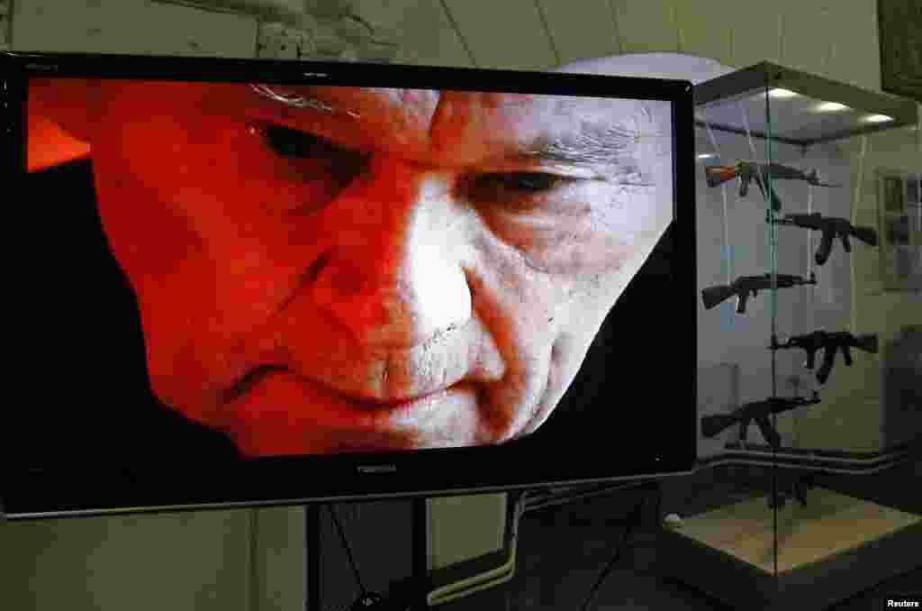 A portrait of Mikhail Kalashnikov is seen on a screen near a display of his weapons during an exhibition at the Artillery Museum in St. Petersburg, Russia. (Reuters/Alexander Demianchuk)