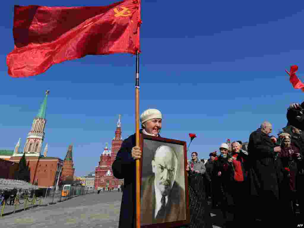 Russian communist supporters holding a portrait of Vladimir Lenin enter Red Square in Moscow on April 22 to pay their respects at his tomb on the 141st anniversary of his birth.Photo by Natalia Kolesnikova for AFP