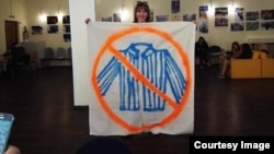 Russian artist Yelizaveta Savolainen with the banner she used to protest against a lecture by a pro-Kremlin activist at the Russian State University for the Humanities. 