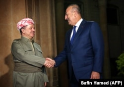 Iraq's Kurdistan region President Masud Barzani (left) meets with Turkish Foreign Minister Mevlut Cavusoglu in Irbil on August 23.