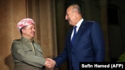 The president of Iraq's Kurdish autonomous region, Masud Barzani (left), meets with Turkish Foreign Minister Mevlut Cavusoglu in Irbil on August 23.