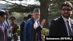Afghan President Hamid Karzai speaks with journalists after the Eid prayer on October 15.