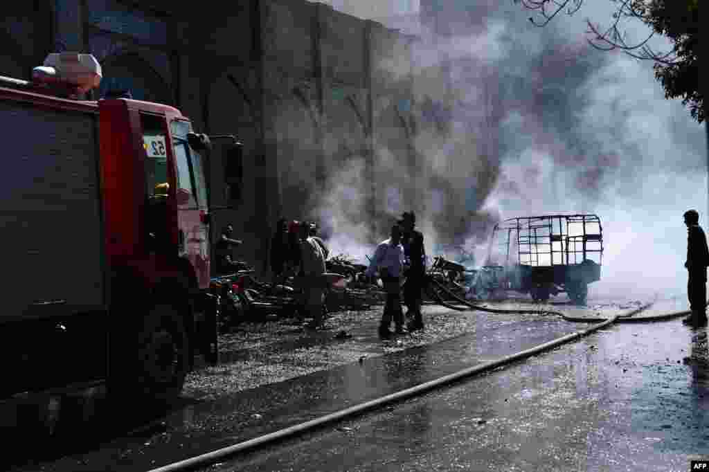 Afghan firefighters extinguish a fire at the site of a motorcycle bomb explosion in front of the Jami Mosque that killed seven people in Herat on June 6.&nbsp;