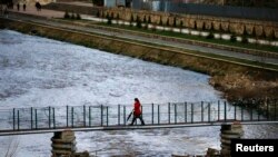 Kosovo -- A woman walks over a bridge in the ethnically divided town of Mitrovica, 20Mar2013