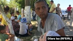 Эвакуированные из Арыси в Шымкент люди сидят на прилегающей к мечети территории. 24 июня 2019 года.