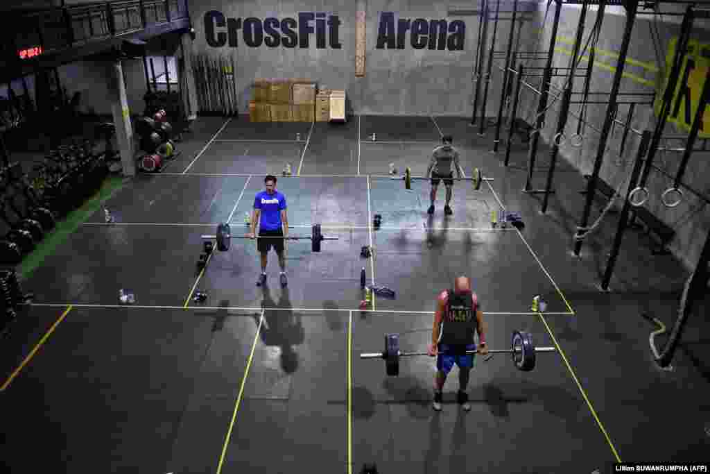 Gym enthusiasts do deadlifts whilst maintaining distance from each other at CrossFit Arena Bangkok, during their first week of reopening following closure of physical wellness centers after authorities lifted some measures of restrictions to halt the spread of the COVID-19 coronavirus in Bangkok on May 20, 2020.