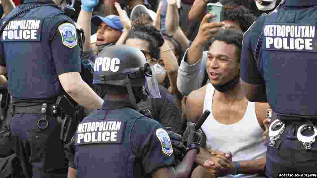 Возле Белого дома полицейские опустились на колено перед сотнями протестующих. Вашингтон, 31 мая 2020 года.