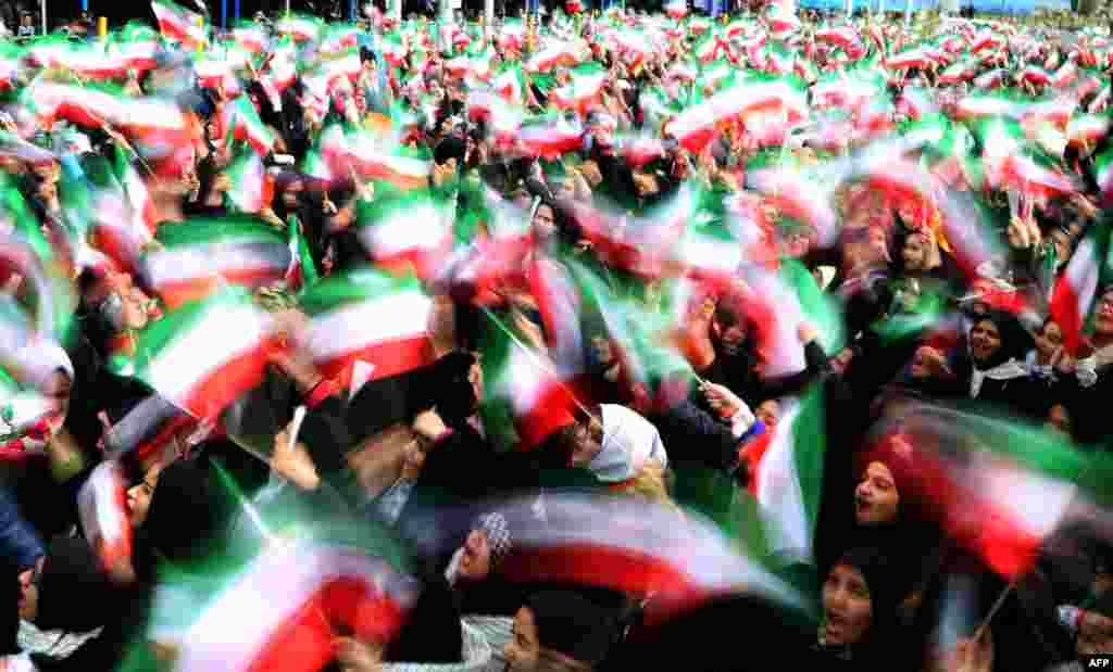 Nxënëset iraniane valëvitin flamuj kombëtar gjatë festimeve në Sheshin e Lirisë në Teheran, për të shënuar 37-vjetorin e Revolucionit Islamik.