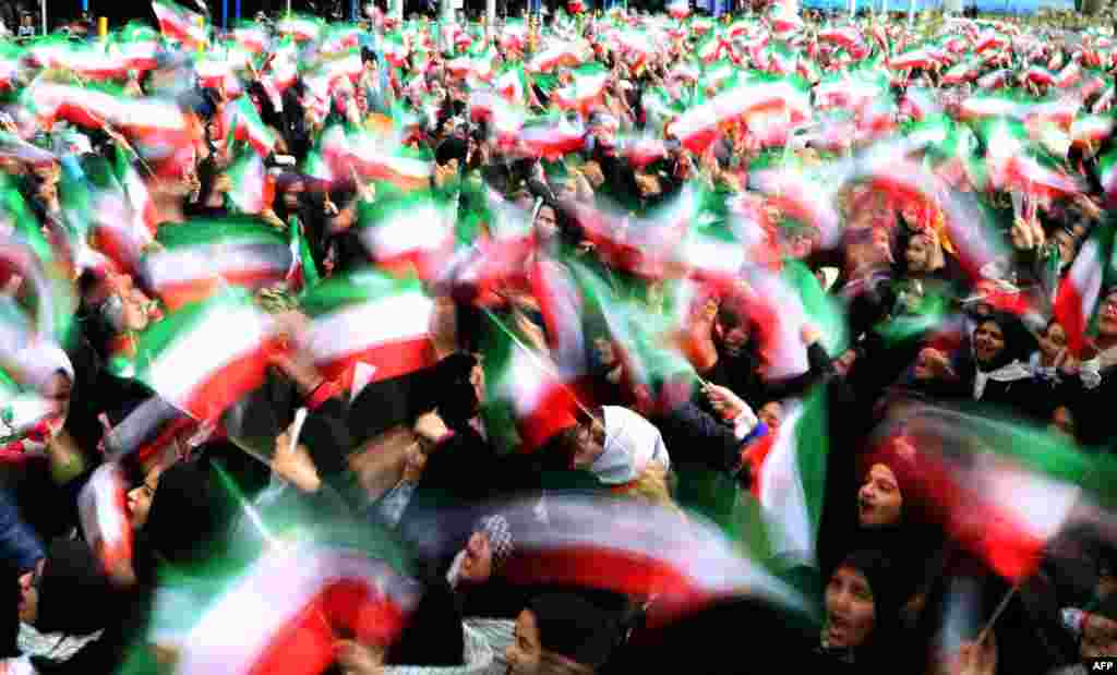 Iranian schoolgirls wave their national flag during celebrations on Tehran's Freedom Square to mark the 37th anniversary of the Islamic Revolution on February 11. (AFP/Atta Kenare)