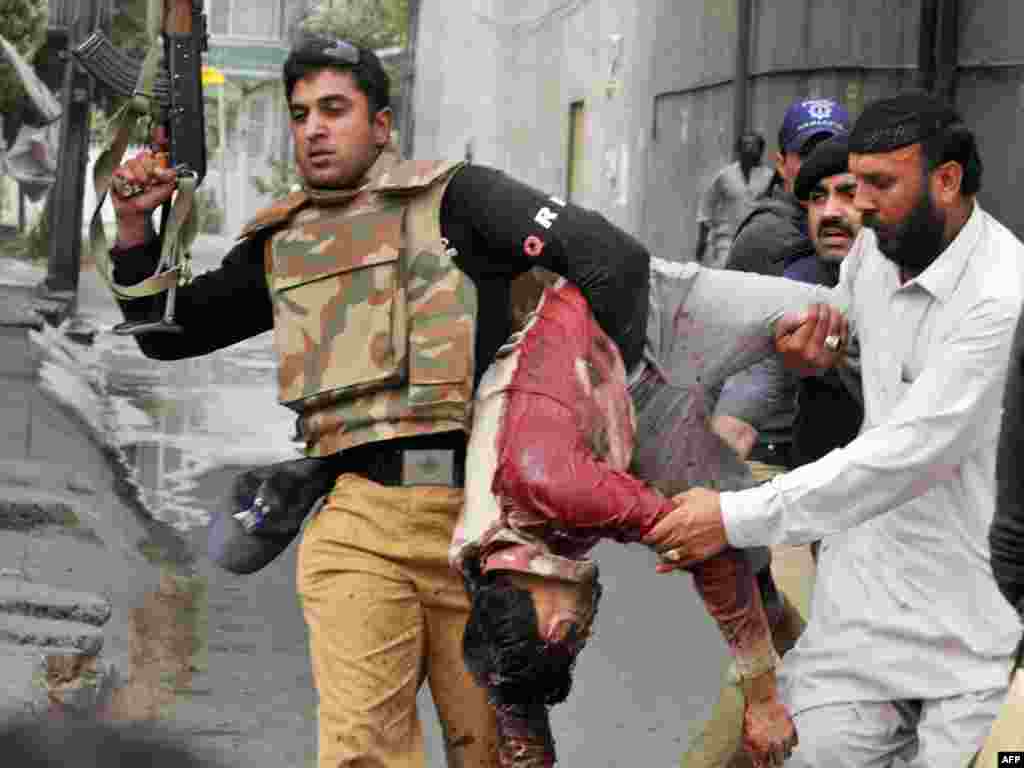 Полицейские эвакуируют тело жертвы нападения на мечети в Лахоре