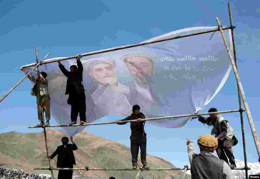 Supporters of Afghan presidential candidate Abdullah Abdullah hang up a banner before an election campaign in Panjshir Province. (Reuters/Ahmad Masood)