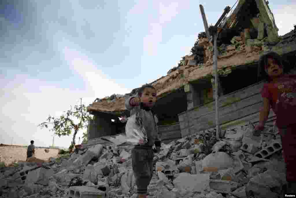 A boy shows a dead pigeon at a site hit previously by an air strike in the rebel-held Douma neighborhood of Damascus on October 12. (Reuters/Bassam Khabieh)