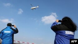 Observatori OSCE in Ucraina testează o dronă.