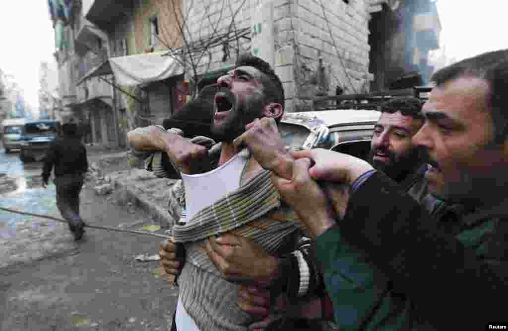 A father reacts after the death of two of his children, whom activists said were killed by shelling by forces loyal to Syria&#39;s President Bashar al-Assad, in Aleppo on January 3. (Reuters/Muzaffar Salman)