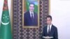  Serdar Berdimuhamedow prezident kakasynyň portretiniň öňünde prezidente hasabat berýär.