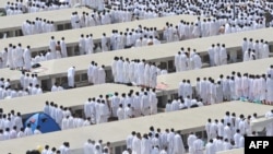 Мусульманские паломники совершают полуденную молитву на равнине Арафат на окраине священного города Мекка. Саудовская Аравия, 25 октября 2012 года.