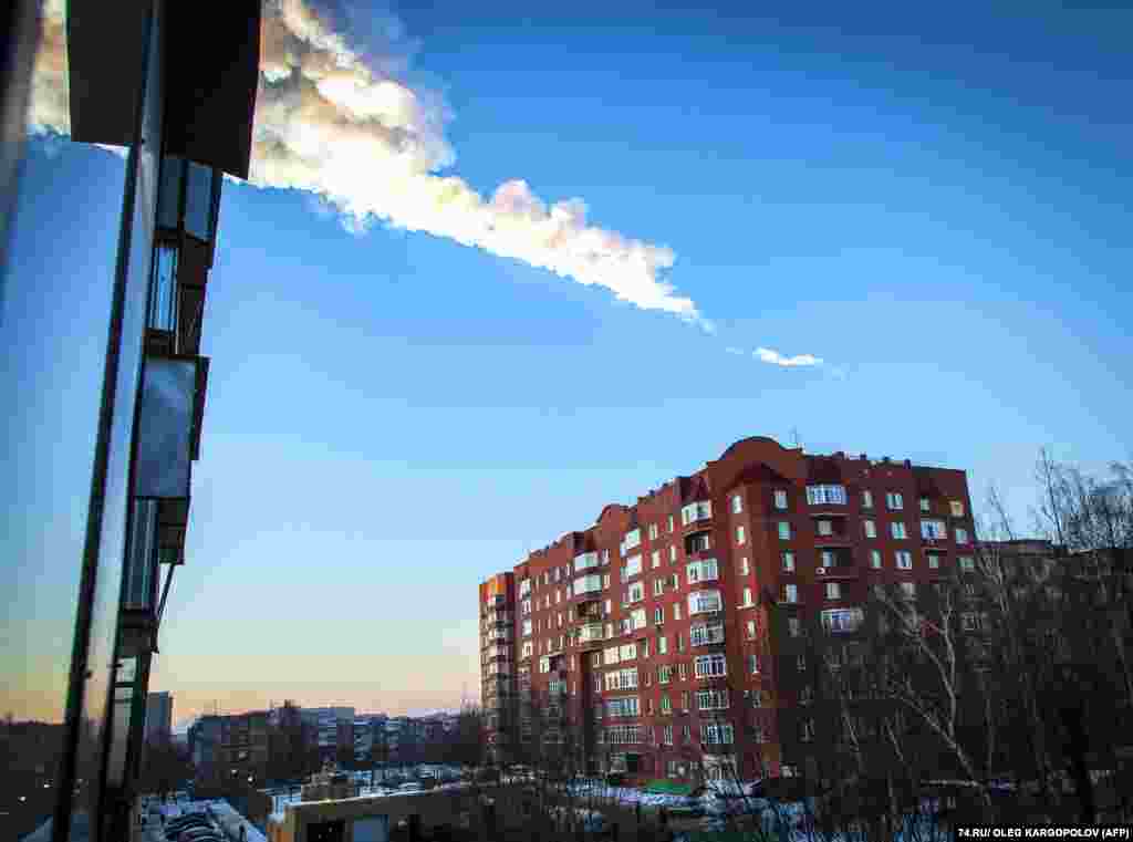 The trail of a meteor is seen above a residential apartment block in the Urals city of Chelyabinsk, Russia. The strike caused widespread injuries and damage. (AFP/Oleg Kargopolov)