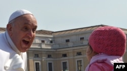 VATICAN -- Pope Francis salutes a young girl as he arrives for his weekly general audience at St Peter's square on 24Apr2013 at the Vatican. 