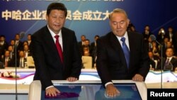 China's Xi Jinping (left) and Kazakhstan's Nursultan Nazarbaev put their palms on a screen during a gas-pipeline-launching ceremony in Astana in September 2013.