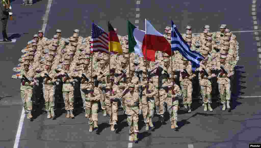 Армянские военнослужащие несут флаги США, Германии, Италии, Польши и Греции на военном параде.