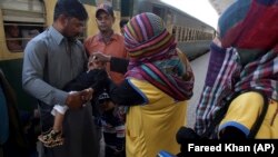 A health worker gives polio vaccine to a child at a railway station in Karachi, Pakistan, in 2018.