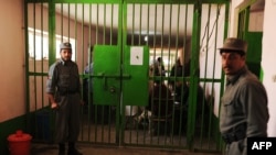 Prison officials stand guard during a visit by local and international media at a Kabul prison.