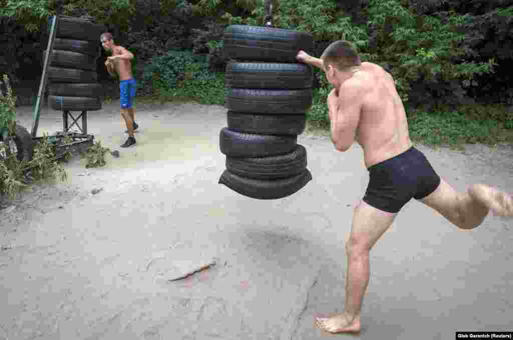 Men pummelling stacks of tires. The gym is free, and never closes.