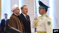 Kazakh President Nursultan Nazarbaev (center) and his Iranian counterpart Hassan Rohani (left) review a guard of honor during a welcoming ceremony before their meeting in Astana on December 22. 