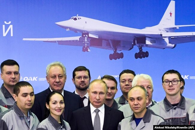 Владимир Путин позирует с работниками Казанского авиационного завода имени С.П.Горбунова 25 января 2018. Там же Путин наблюдал за демонстрационным полётом модифицированного бомбардировщика Ту-160М "Петр Дейнекин".