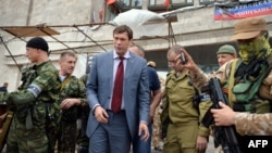Народный депутат Украины Олег Царев (второй слева) стоит рядом с бойцами вооруженного формирования – батальона «Восток» – возле штаб-квартиры подконтрольной России группировки «ДНР» в Донецке, 12 июня 2014 года