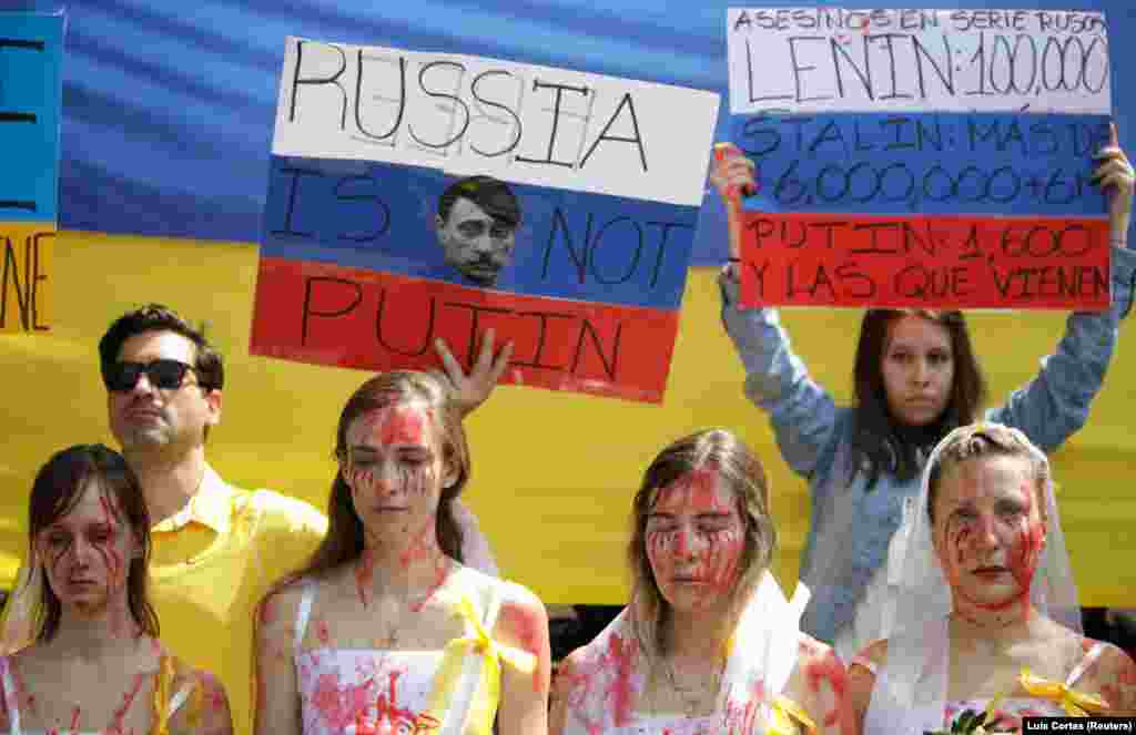 Ukrainian women dressed as bloodied brides and people holding placards take part in a protest outside the Russian Embassy in Mexico City on February 26.